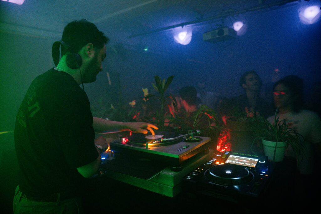 A DJ Behind some turntables at a dance party